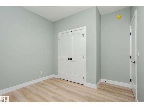 Light wood-finish flooring complements the neutral wall color - 6302 Dansereau Crescent, Beaumont, AB - Indoor Photo Showing Other Room