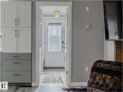 Entryway featuring a white door with decorative glass inserts and a decorative pendant light fixture - 