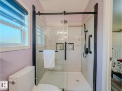 Contemporary shower enclosure with matte black hardware and clear glass sliding door - 