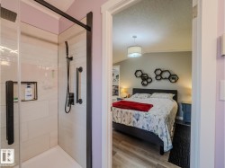 Glass-enclosed shower with matte black fixtures, white subway tile surround, and a built-in shower niche - 