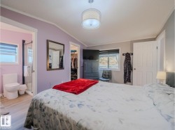 Spacious room featuring a vaulted ceiling and a drum pendant light fixture - 