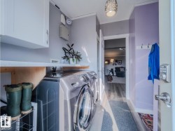 Functional utility area featuring a front-load washer and dryer, upper white cabinetry, and a countertop - 