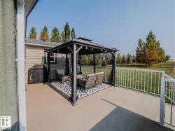 Exterior deck featuring a black metal gazebo with string lighting, providing a dedicated outdoor living space - 