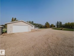 Detached garage with light-colored siding and a white overhead door - 