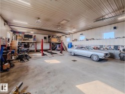 Spacious garage with high ceilings, concrete flooring, ample built-in cabinetry, and integrated overhead lighting - 