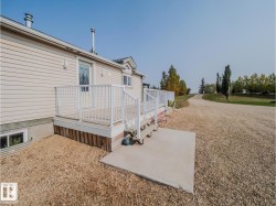 Exterior entrance featuring a light-colored deck with white railings and steps - 