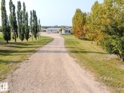 Gravel driveway leading to a residence with a covered porch - 