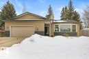 The property features a tan exterior with dark stone accents, an attached garage, and prominent bay windows - 7 Ash Place, St. Albert, AB  - Outdoor 