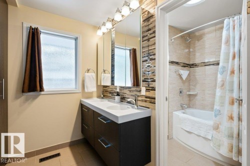 The bathroom features a double vanity with ample storage and a contemporary tiled backsplash - 7 Ash Place, St. Albert, AB - Indoor Photo Showing Bathroom