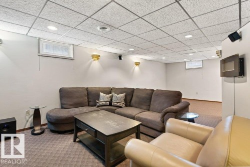 Well-lit entertainment area featuring recessed lighting, wall sconces, and patterned carpeting - 7 Ash Place, St. Albert, AB - Indoor