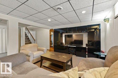 Living area featuring a textured ceiling, recessed lighting, and a prominent media center with a dark, reflective finish - 7 Ash Place, St. Albert, AB - Indoor Photo Showing Living Room