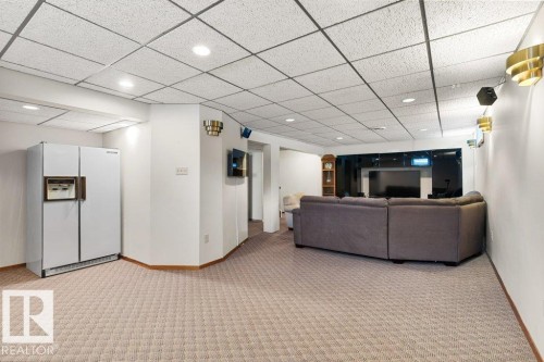 This spacious room features wall-to-wall carpeting, recessed lighting, and wall sconces, providing a versatile living area - 7 Ash Place, St. Albert, AB - Indoor Photo Showing Other Room