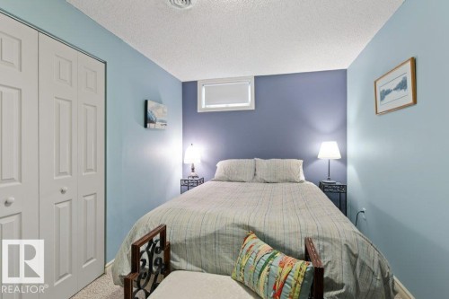 This room features light blue walls, a window, and white bi-fold closet doors - 7 Ash Place, St. Albert, AB - Indoor Photo Showing Bedroom
