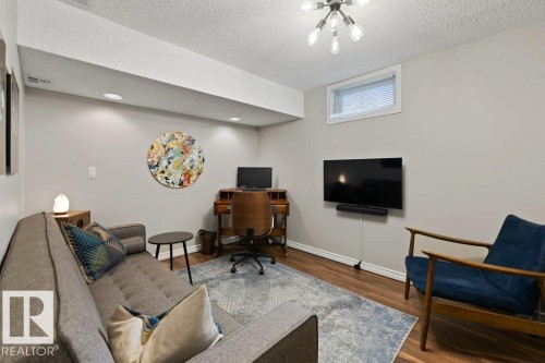 This versatile room features hardwood flooring, recessed lighting, and a modern ceiling light fixture - 7 Ash Place, St. Albert, AB - Indoor Photo Showing Living Room