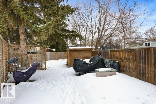 The property features a fenced yard with a storage shed and mature trees - 7 Ash Place, St. Albert, AB - Outdoor