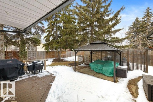 The property features a spacious backyard with a wooden deck, a gazebo, and mature evergreen trees - 7 Ash Place, St. Albert, AB - Outdoor With Deck Patio Veranda