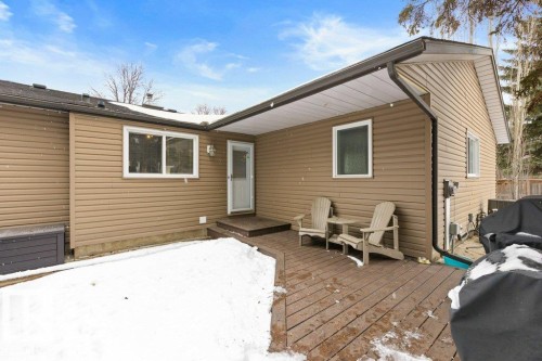 The property features a brown wood deck with stairs leading to a white door, and an exterior with brown siding - 7 Ash Place, St. Albert, AB - Outdoor With Deck Patio Veranda With Exterior