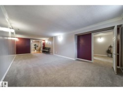 Spacious room featuring light grey carpeting and a white crown molding detail - 