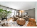 Bay window with shutter blinds, wood-finish flooring, and a neutral wall palette - 10231 46 Street, Edmonton, AB 