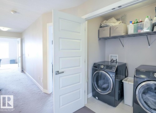 Dedicated laundry area featuring a tile floor, white shaker-style door, and wire shelving - 1728 53 Street, Edmonton, AB - Indoor Photo Showing Laundry Room