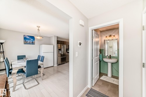 Pedestal sink with dark-finish faucet and rectangular mirror in a half bath featuring green wainscoting - 328 Watt Boulevard, Edmonton, AB - Indoor