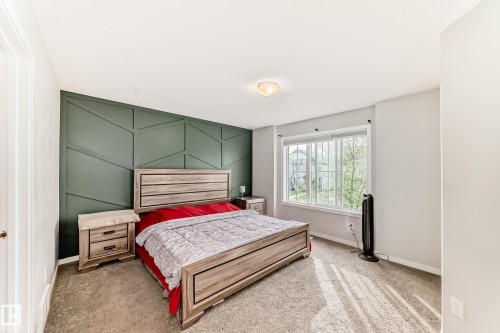 Bedroom featuring a geometric accent wall, carpet flooring, and a large window - 328 Watt Boulevard, Edmonton, AB - Indoor Photo Showing Bedroom