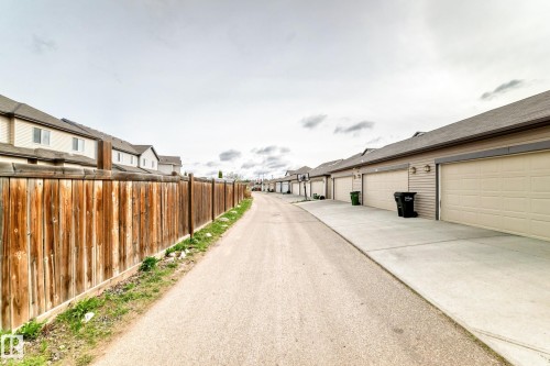 Paved alleyway providing access to multiple attached garages with concrete driveways - 328 Watt Boulevard, Edmonton, AB - Outdoor With Exterior