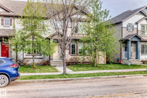 Two-story residential facade featuring light-colored siding, a dark roof, and a covered porch entry - 328 Watt Boulevard, Edmonton, AB - Outdoor