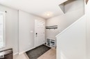 Entryway featuring a white paneled door with decorative glass, tiled flooring, a coat rack with five hooks, and light neutral wall paint - 328 Watt Boulevard, Edmonton, AB  - Indoor Photo Showing Other Room 