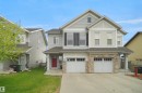 Two-story home with a two-car garage, stone veneer accents, and a red entry door - 1702 Chapman Way, Edmonton, AB  - Outdoor With Facade 