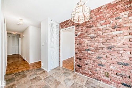 Foyer featuring a decorative overhead light fixture, a brick accent wall, and tiled flooring - 79 Broadview Crescent, St. Albert, AB -  Photo Showing Other Room