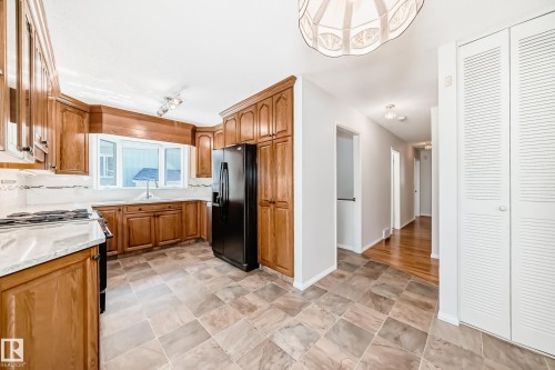 Kitchen featuring wood cabinetry, a bay window, and a black refrigerator - 79 Broadview Crescent, St. Albert, AB - Indoor Photo Showing Kitchen