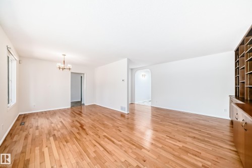 Spacious interior room featuring wood-finish flooring, white wall finishes, and a multi-pane window - 79 Broadview Crescent, St. Albert, AB - Indoor Photo Showing Other Room