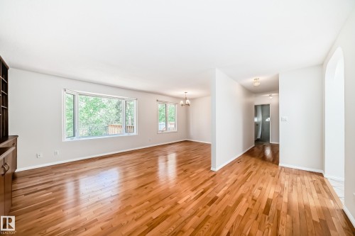 Spacious room featuring wood-finish flooring, light-toned walls, and a large bay window - 79 Broadview Crescent, St. Albert, AB - Indoor Photo Showing Other Room