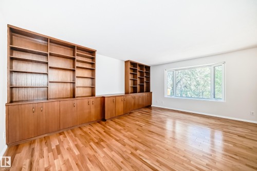 Hardwood flooring throughout featuring extensive built-in cabinetry with open shelving and lower storage - 79 Broadview Crescent, St. Albert, AB - Indoor Photo Showing Other Room