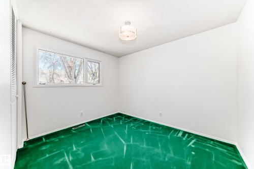 Bright room featuring white walls, green patterned carpet, and a multi-pane window - 79 Broadview Crescent, St. Albert, AB - Indoor Photo Showing Other Room