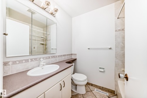 Bathroom featuring a white ceramic vanity sink, a recessed medicine cabinet, a three-light vanity fixture, and tiled flooring - 79 Broadview Crescent, St. Albert, AB - Indoor Photo Showing Bathroom