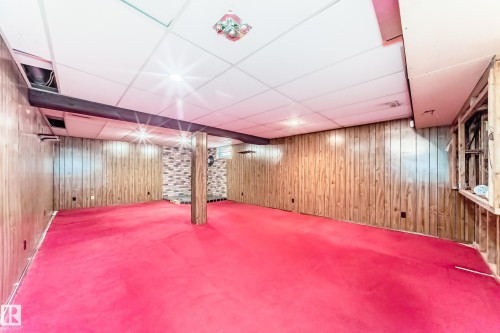 Spacious room featuring wood paneling walls and red carpeting - 79 Broadview Crescent, St. Albert, AB - Indoor