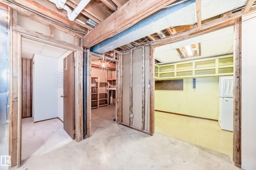 Unfinished basement area featuring exposed wood framing and ceiling joists, concrete flooring, and multiple doorways leading to other unfinished spaces - 79 Broadview Crescent, St. Albert, AB - Indoor Photo Showing Basement