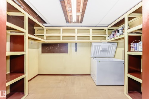 Storage space featuring extensive built-in shelving, durable flooring, and a drop ceiling with recessed lighting - 79 Broadview Crescent, St. Albert, AB - Indoor With Storage
