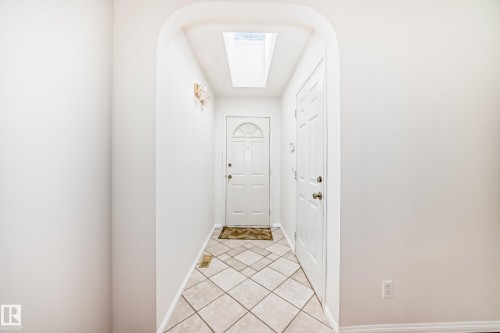Entryway featuring a skylight, arched doorway, two white panel doors, and diagonal tile flooring - 79 Broadview Crescent, St. Albert, AB - Indoor Photo Showing Other Room