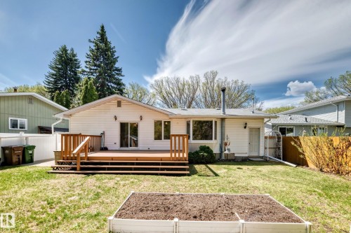 Spacious backyard featuring a multi-level wood deck with railings, an expansive lawn, and a raised garden bed - 79 Broadview Crescent, St. Albert, AB - Outdoor With Deck Patio Veranda