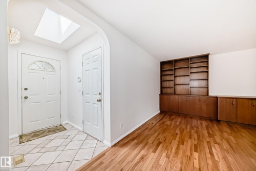 Entrance foyer featuring a skylight and ceramic tile flooring, transitioning to wood-finish flooring - 79 Broadview Crescent, St. Albert, AB - Indoor Photo Showing Other Room