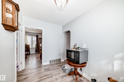 Light wood-finish flooring extends throughout this interior space - 11303 60 Street, Edmonton, AB - Indoor Photo Showing Other Room