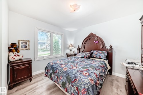 Bedroom featuring wood-finish flooring, a double-pane window, and a ceiling-mounted light fixture - 11303 60 Street, Edmonton, AB - Indoor Photo Showing Bedroom