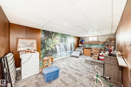 Finished basement space featuring wood paneling, a drop ceiling, and patterned carpet flooring - 11303 60 Street, Edmonton, AB - Indoor Photo Showing Other Room
