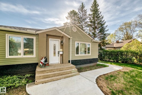 Ranch-style exterior with green siding and a dark stone-look foundation - 11303 60 Street, Edmonton, AB - Outdoor