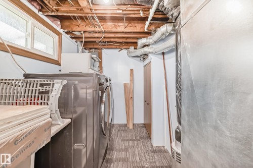 Utility area featuring exposed joist ceiling, patterned floor tile, and a window with wood trim - 11303 60 Street, Edmonton, AB - Indoor