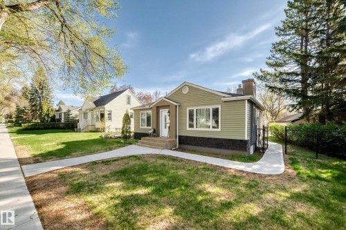 Single-story residence featuring light green siding and dark stone facade detailing - 11303 60 Street, Edmonton, AB - Outdoor With Facade