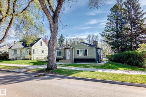 Green siding exterior featuring white trim and a prominent chimney - 11303 60 Street, Edmonton, AB - Outdoor With Facade